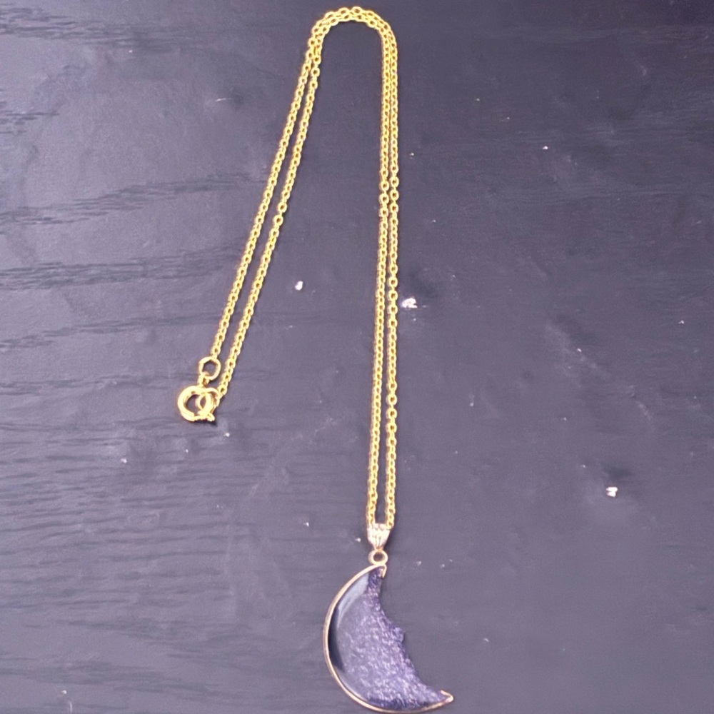 celestial-themed pendant necklace featuring a crescent moon charm with a dark